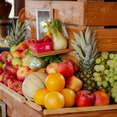 Lerch Businesswelten - Inspirationen an einem Tag Holzkiste mit Äpfeln, Trauben, Ananas, Melonen und weiterem Obst