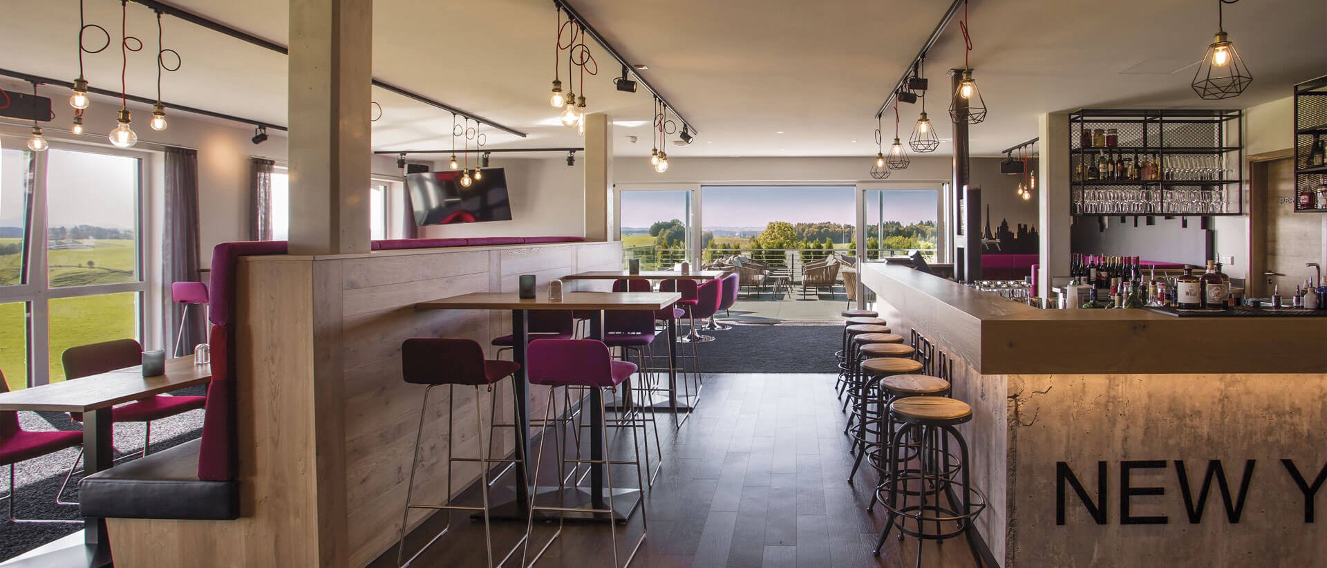 4793 Moderner Hotelbarbereich mit Sitzgelegenheiten und Blick auf grüne Landschaft