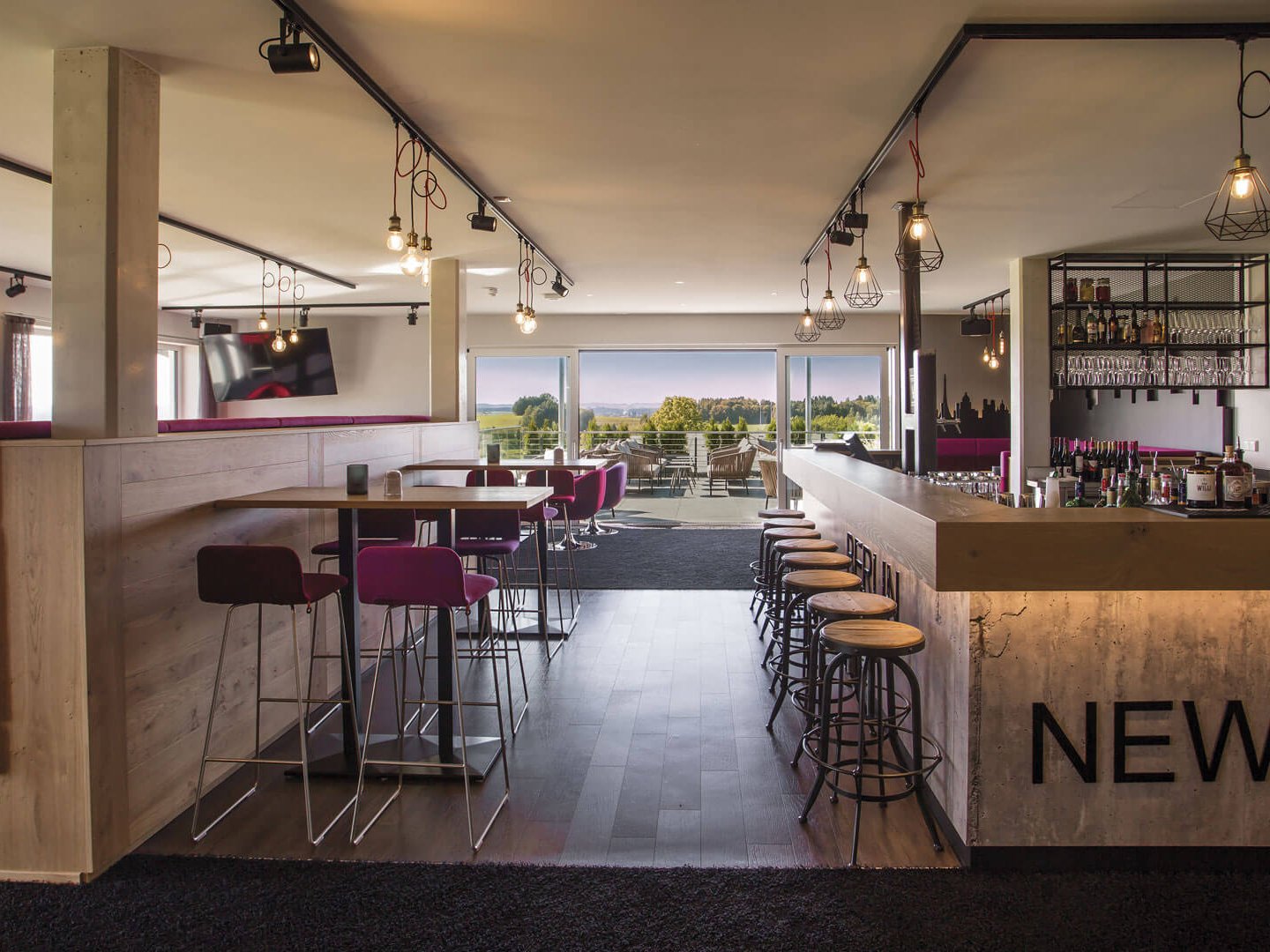 Skybar Moderner Hotelbarbereich mit Sitzgelegenheiten und Blick auf grüne Landschaft