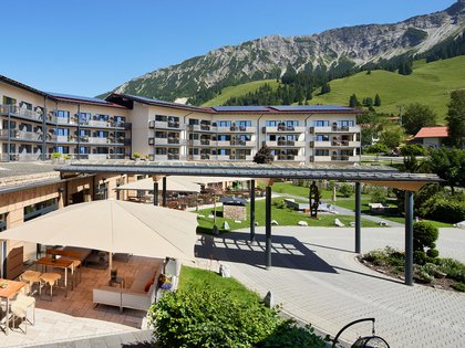 Lerch Businesswelten - Inspirationen an einem Tag Hotel mit Terrasse, Sitzbereichen und Bergblick bei klarem Himmel