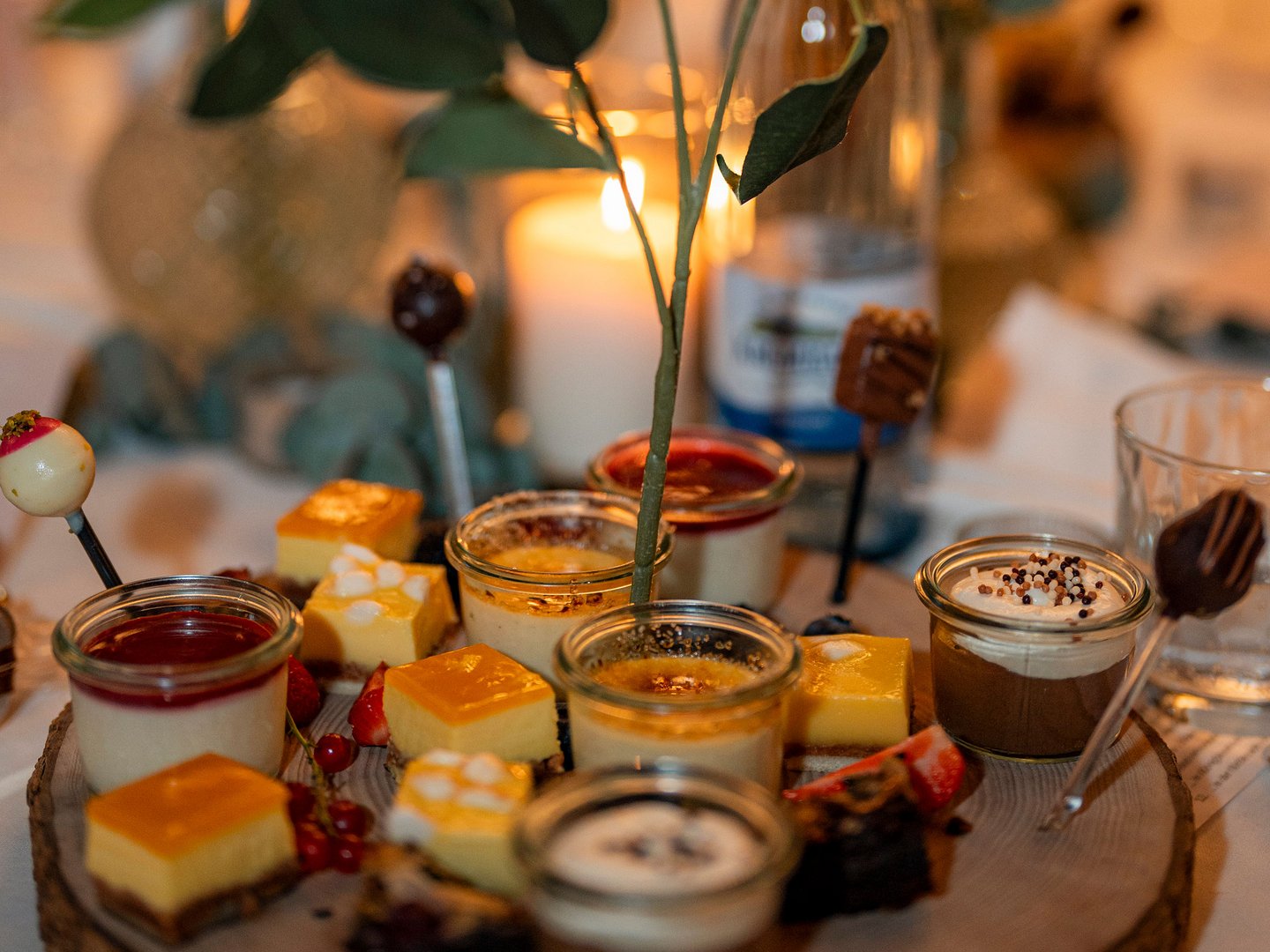 Hotel Das Weitblick Allgäu | Kulinarik für die perfekte Feier Verschiedene Desserts und Kuchen auf einem Holztablett mit Kerzenlicht