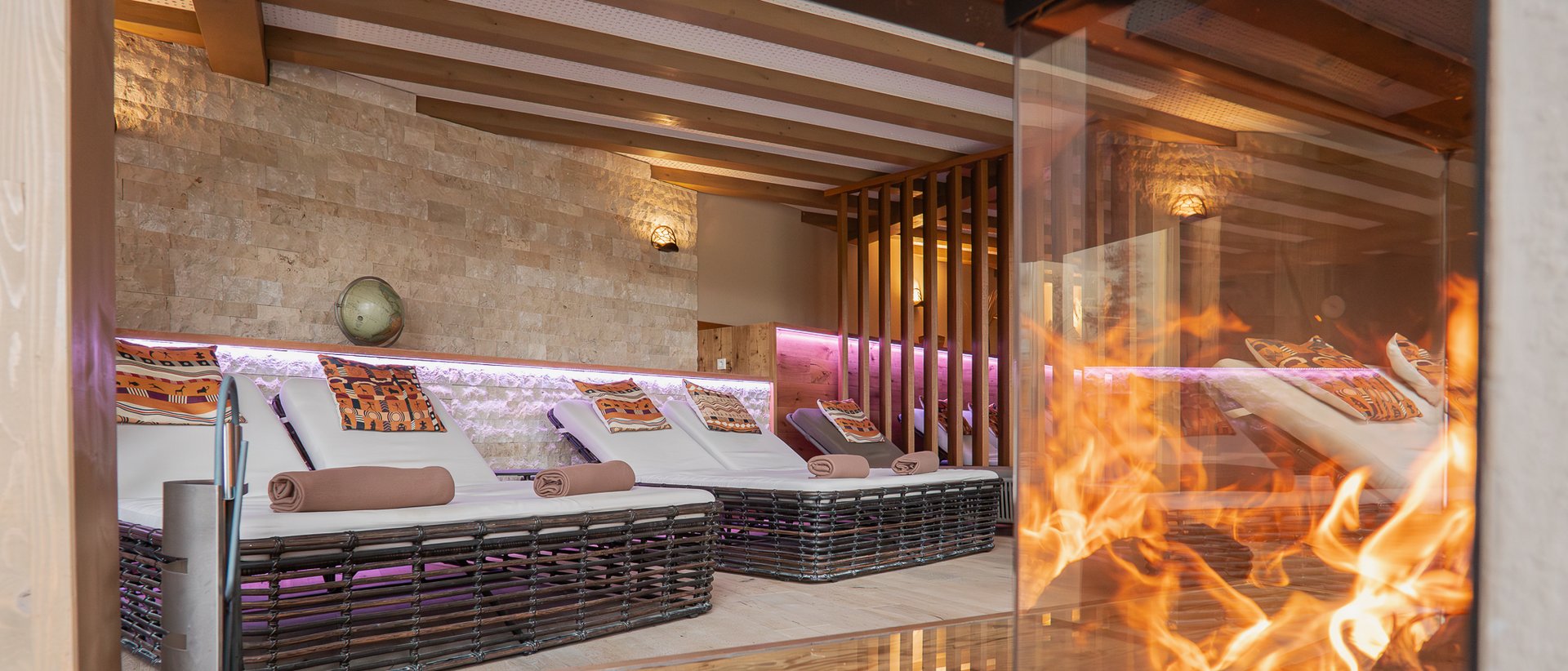 Hotel Das Weitblick Allgäu | Wellnesshotel Marktoberdorf Ruheliegen mit Kissen und Decken in einem gemütlichen Raum mit Kamin