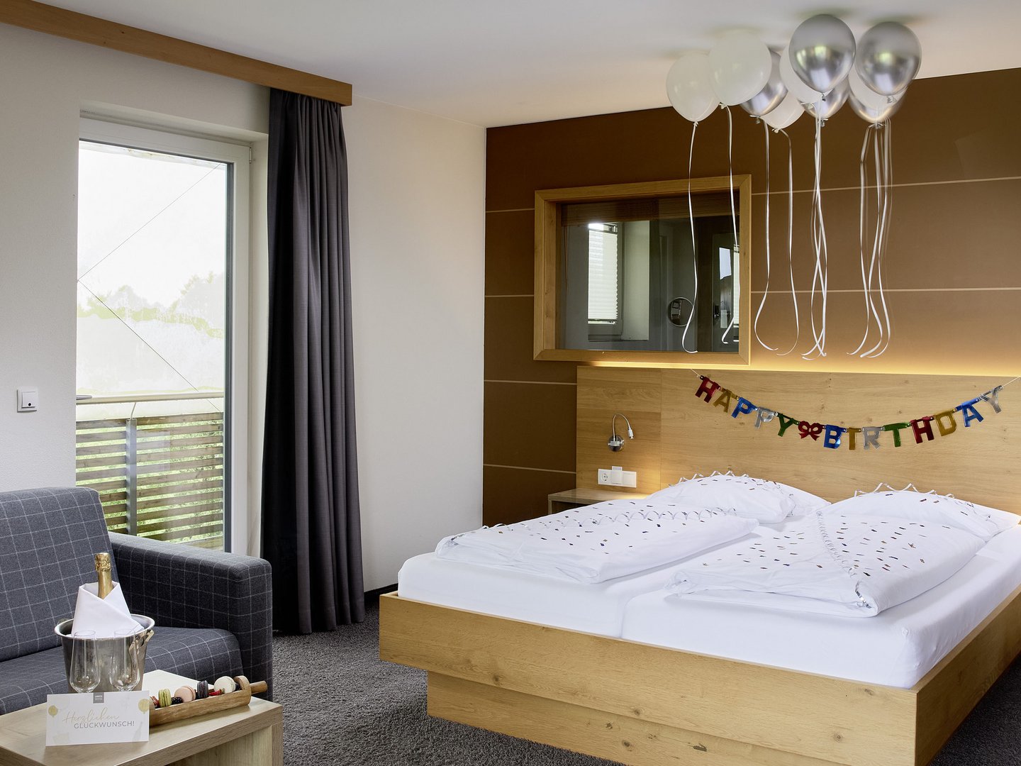 Hotel Das Weitblick Allgäu | Zubuchbare Extras für Magic Moments Hotelzimmer mit Geburtstagsdekoration, Luftballons und Champagner auf Tisch
