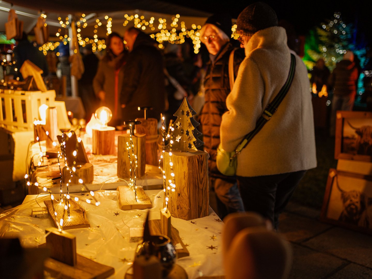 Lichterzauber im Weitblick Allgäu Beleuchteter Weihnachtsmarktstand mit Holzdekoration und Besuchern