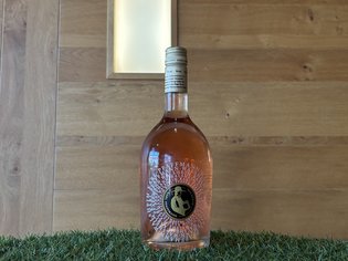 Weinkarte Das Weitblick Allgäu Roséweinflasche vor einer holzvertäfelten Wand auf Kunstrasen