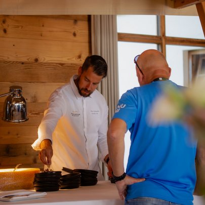 Lerch Businesswelten - Inspirationen an einem Tag Koch und Mann in blauem Hemd an einem Tisch mit schwarzen Tellern