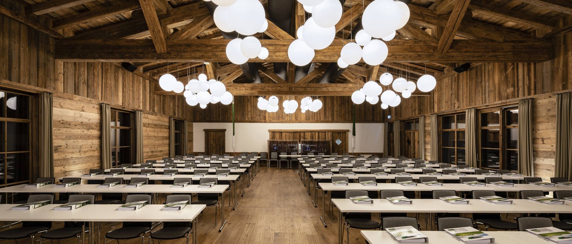 Lerch Businesswelten - Inspirationen an einem Tag Großer Konferenzraum mit Holzwänden und modernen runden Deckenleuchten