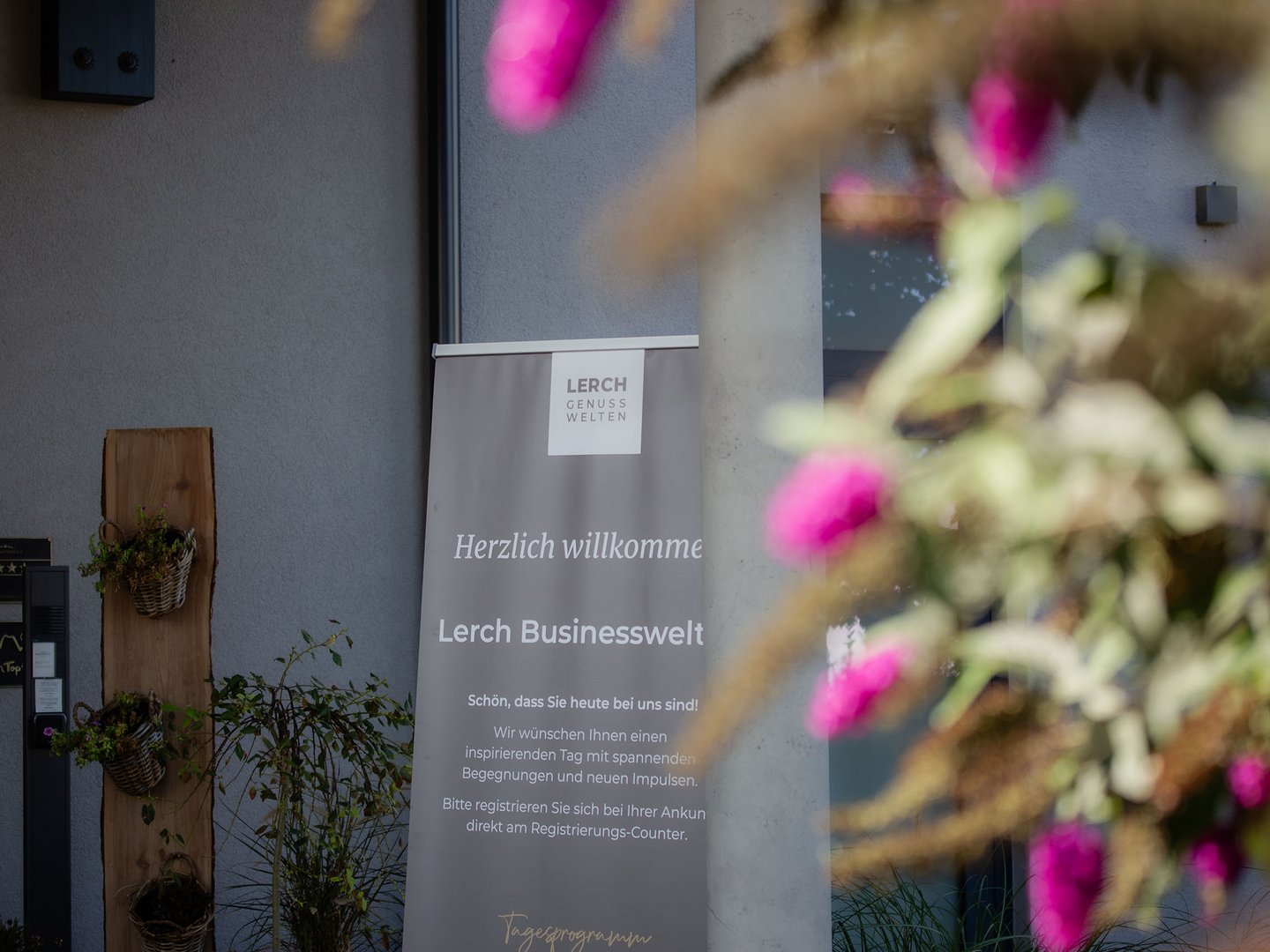 Lerch Businesswelten - Inspirationen an einem Tag Willkommensbanner der Lerch Businesswelt neben blühenden Pflanzen