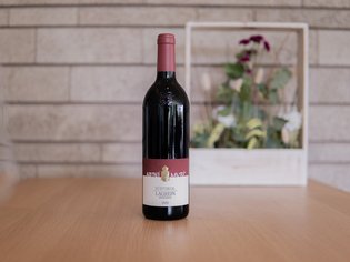Weinkarte Das Weitblick Allgäu Flasche Südtiroler Lagrein Riserva Rotwein auf Holztisch vor Steinwand